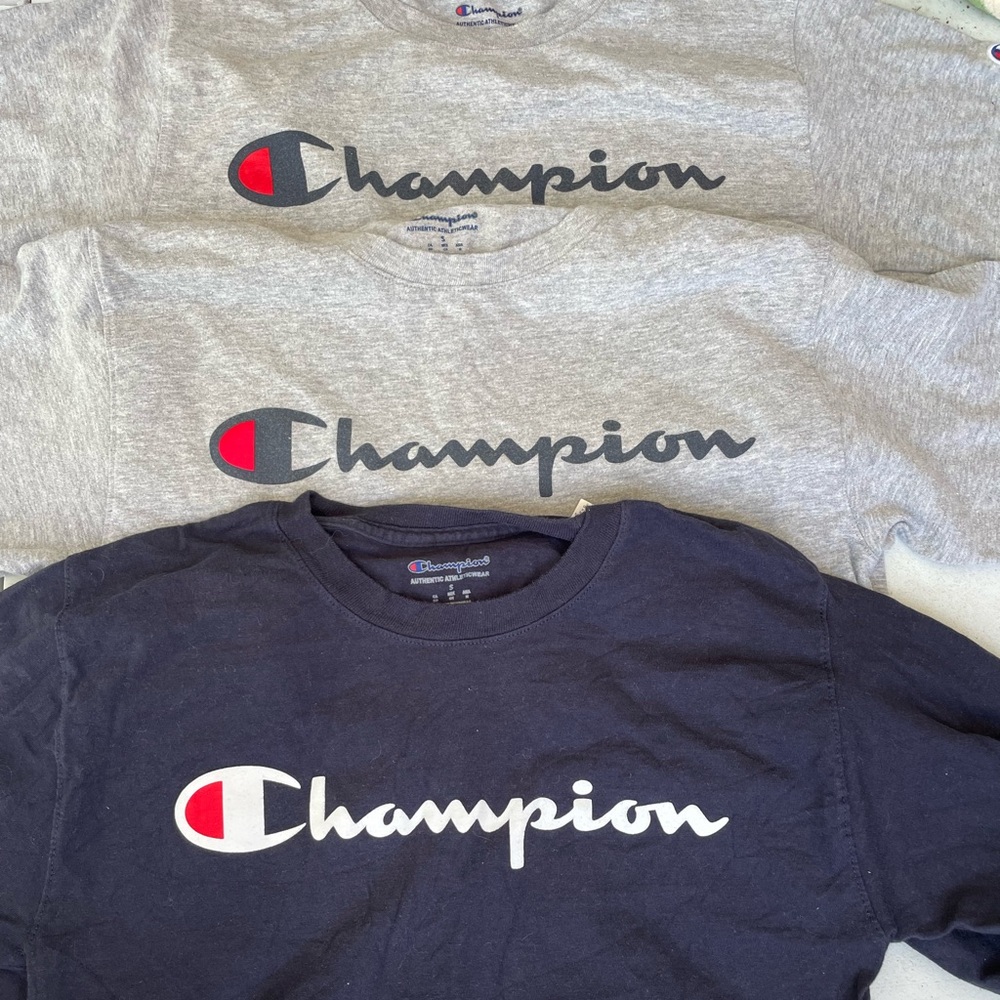 3 Champion shirts size adult small. 2 gray short sleeve, 1 navy long sleeve